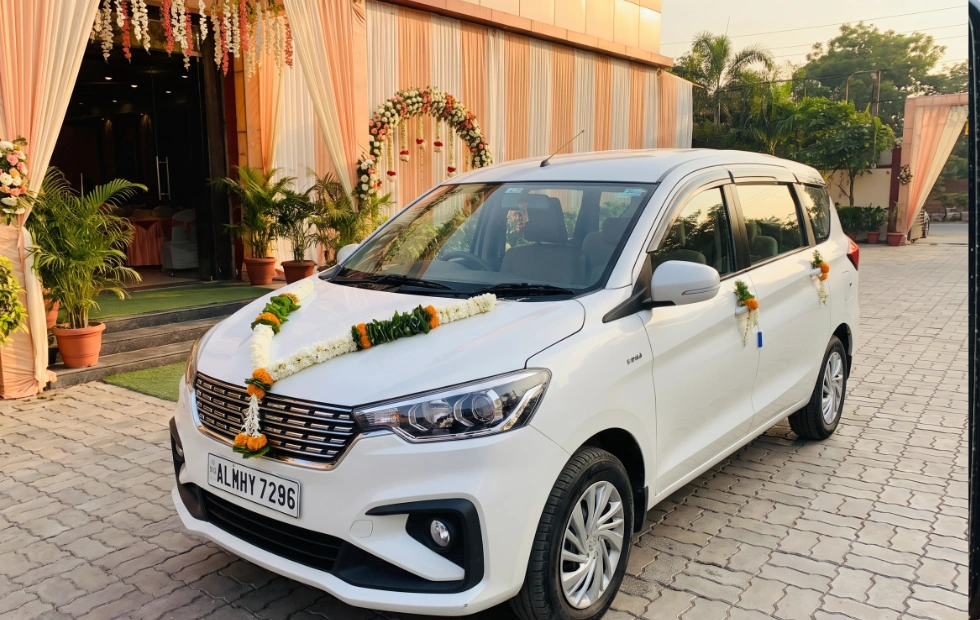 White Maruti Suzuki Ertiga decorated with flowers for marriage and wedding guest transport in Coimbatore
